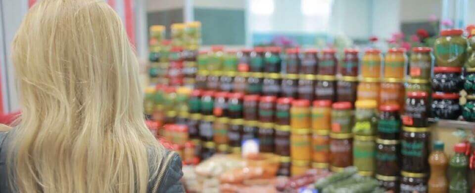 Woman in front of shelf full of jam jars