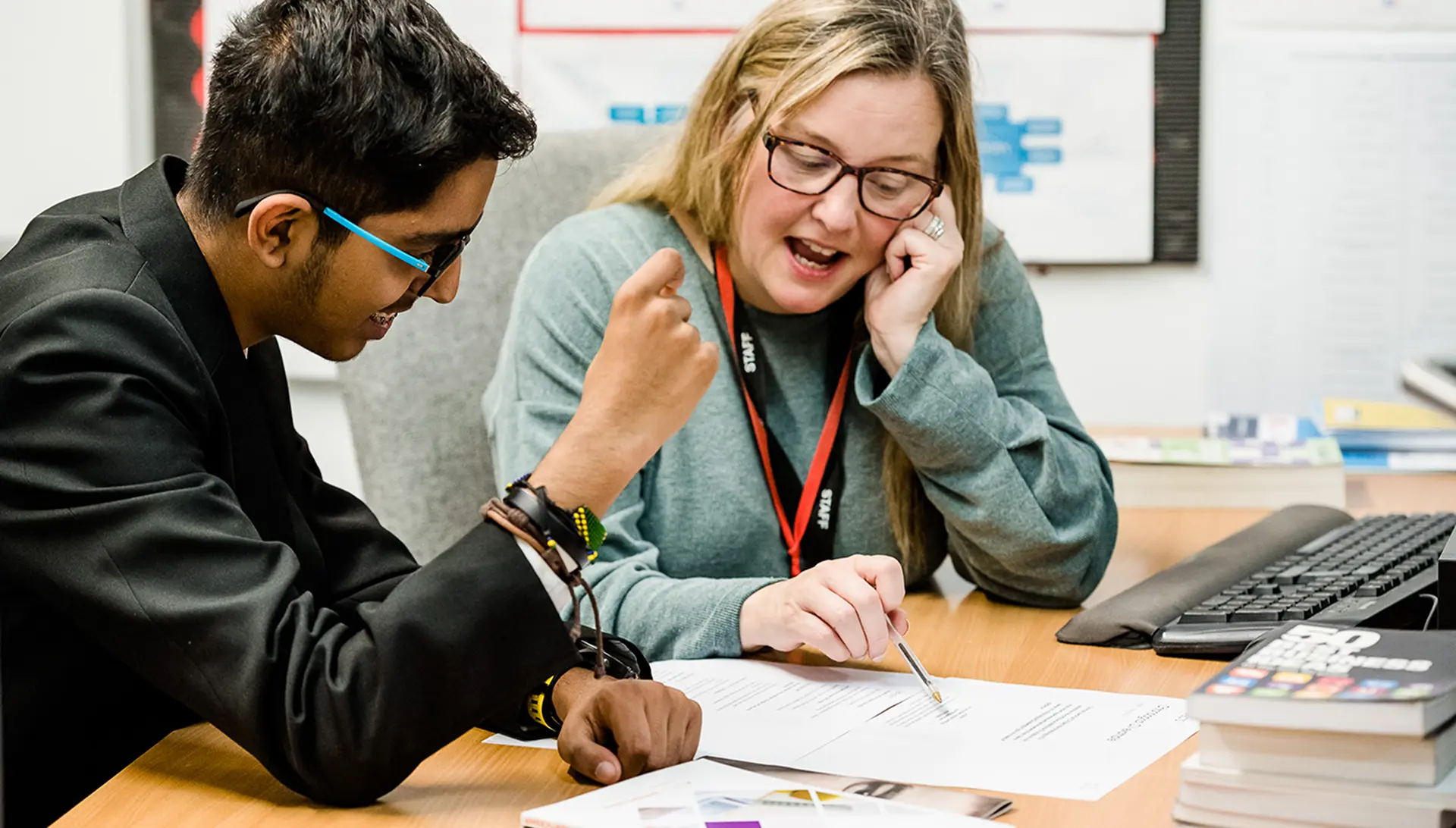 Image of a teacher and student in discussion at a desk