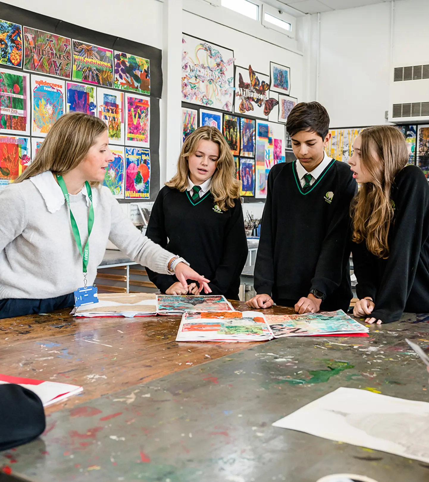 Image of students and a teacher discussing work